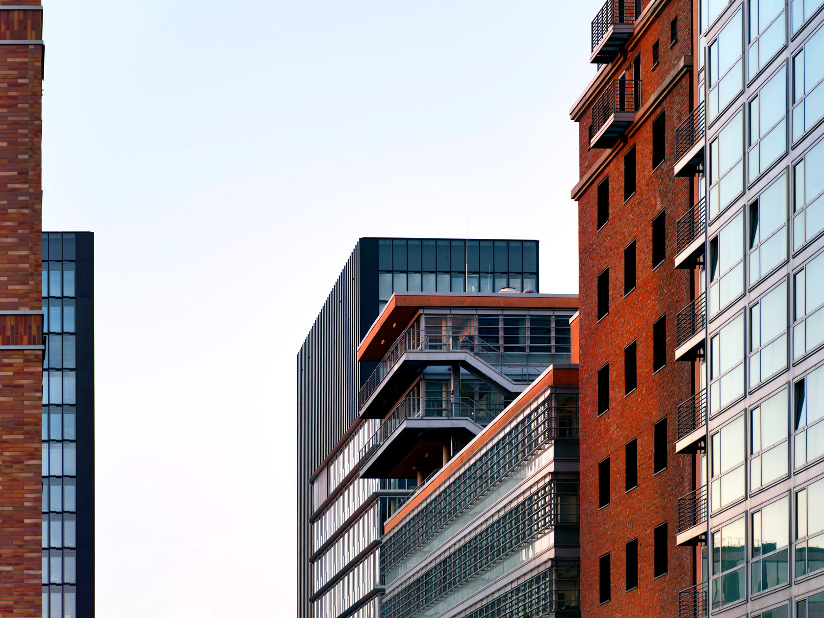 Die Fotografie von Herbert Böttcher zeigt eine rote Backsteinfassade neben modernen Glas‑ und Metallgebäuden im Medienhafen Düsseldorf.